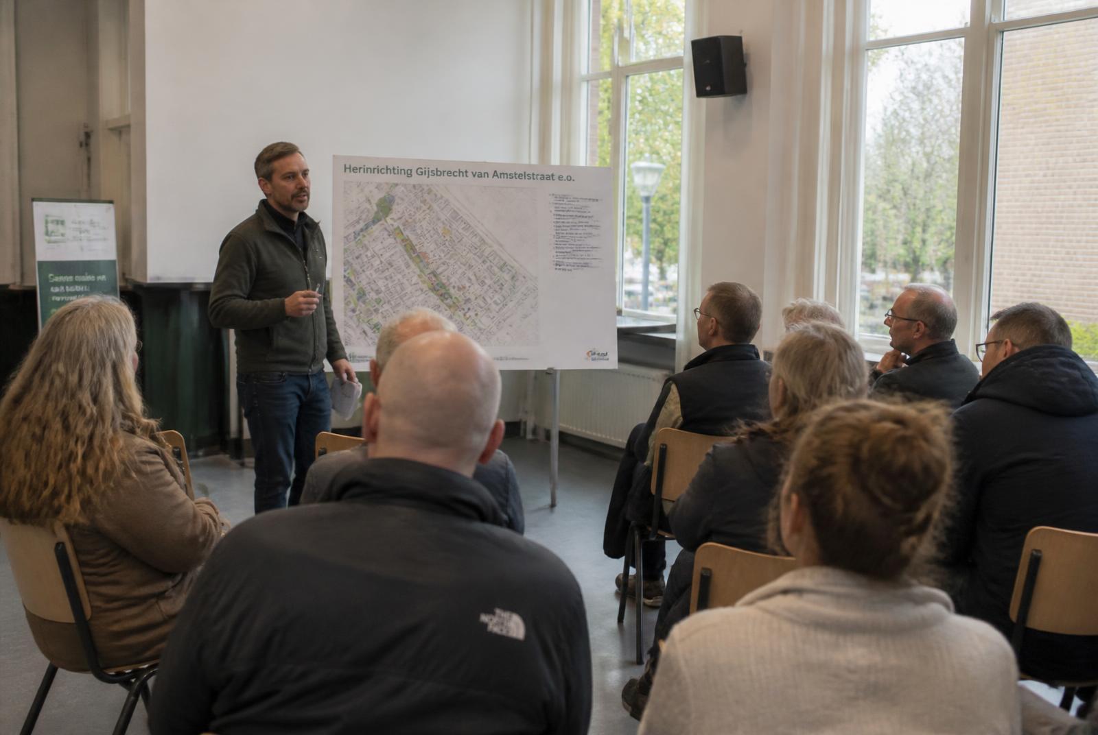 Bewonersbijeenkomst in een buurthuis met een plankaart van de wijk
